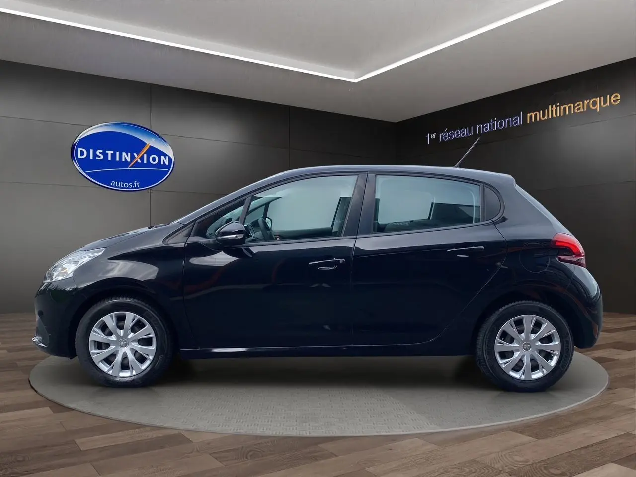 Profil côté gauche d'une Peugeot 208 Affaire Premium Pack noire, 5 portes, en présentation showroom avec jantes argentées.