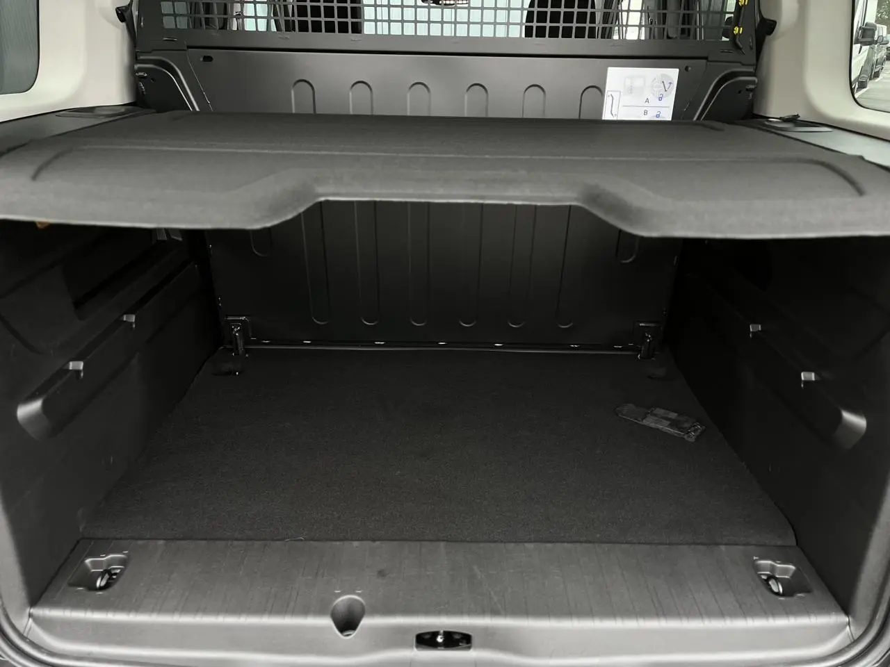 Vue intérieure du coffre noir du Citroën Berlingo Multispace M 2025, montrant la lunette arrière ouvrante et la séparation rigide.