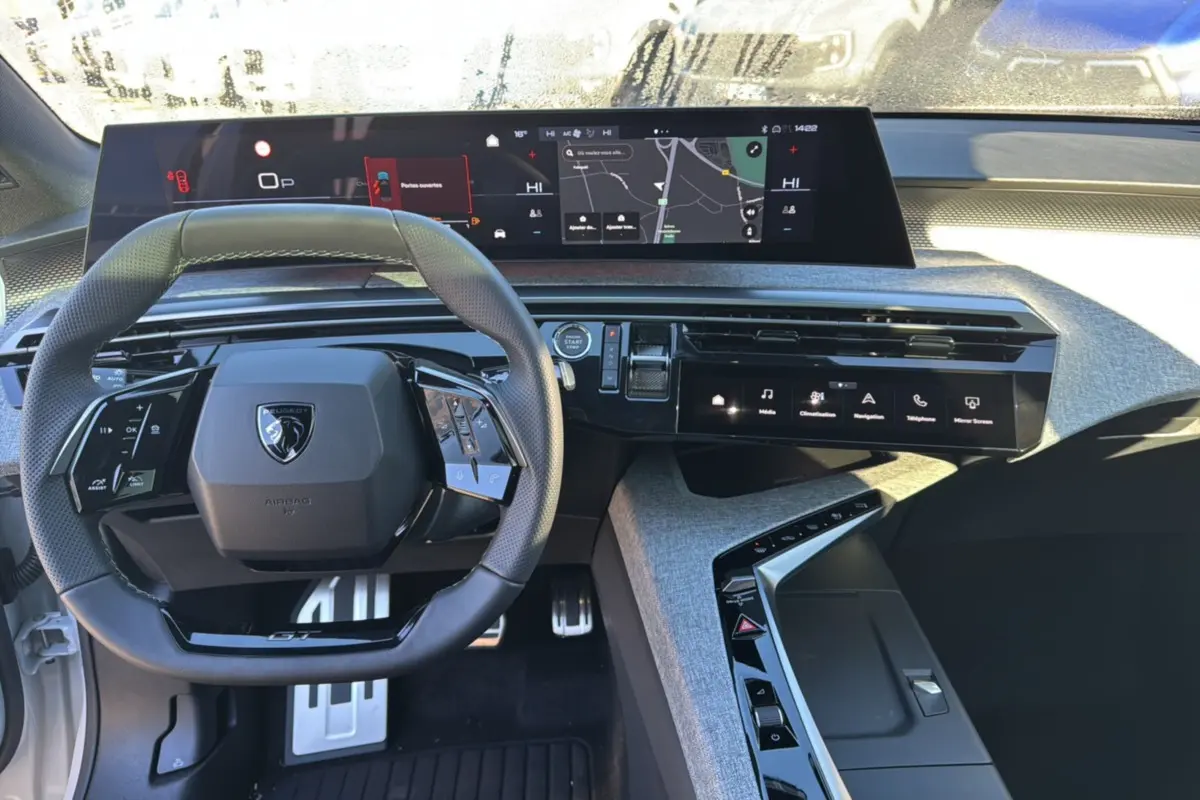 Vue intérieure du tableau de bord du Peugeot 3008 Hybrid 2025 avec volant cuir multifonctions et écran tactile panoramique.