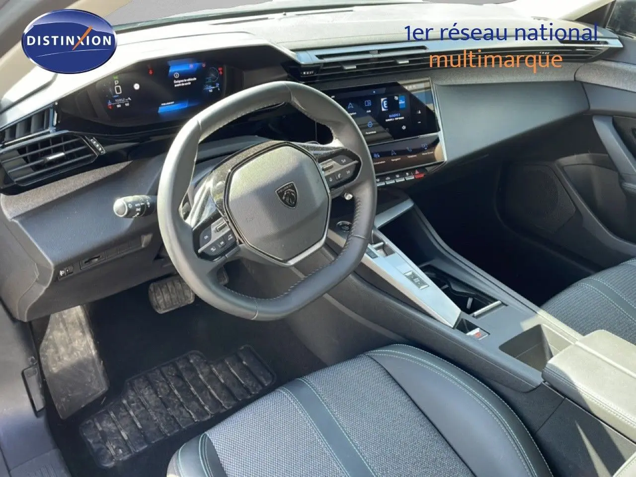 Intérieur avant droit de la Peugeot 308 SW gris Artense, volant multifonction et écran tactile central visibles.