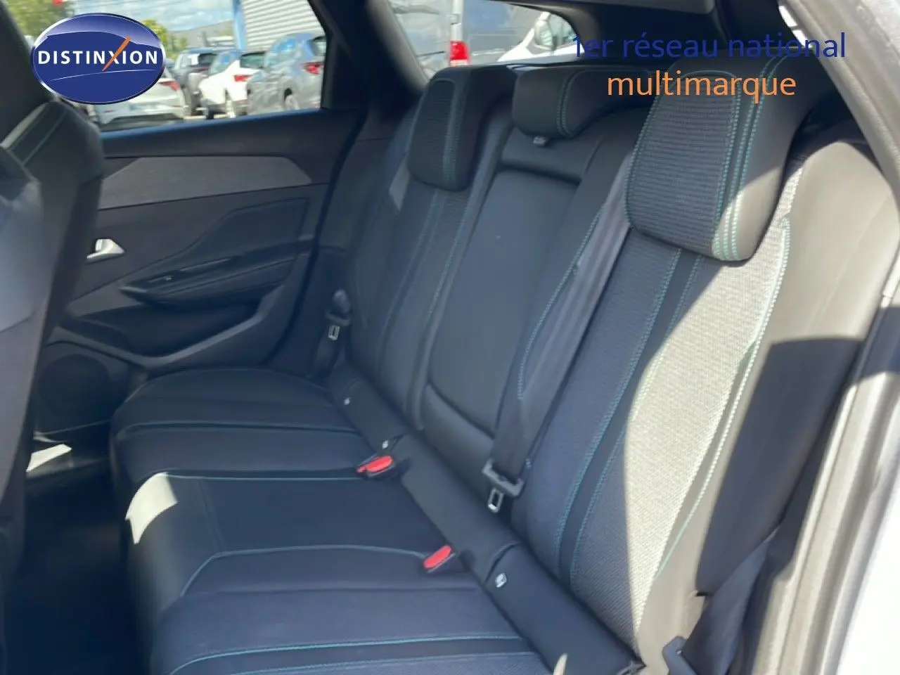 Vue intérieure côté droit montrant la banquette arrière en tissu et cuir gris avec surpiqûres bleues du Peugeot 308 SW 2025.