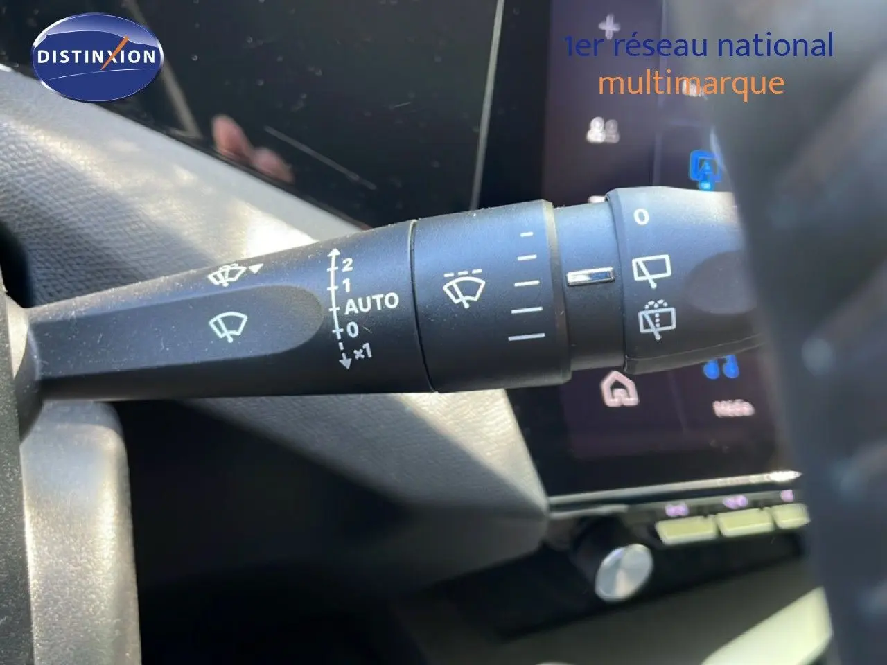 Gros plan sur la commande d’essuie-glace du Peugeot 308 SW Hybrid 2025, avec tableau de bord numérique en arrière-plan.