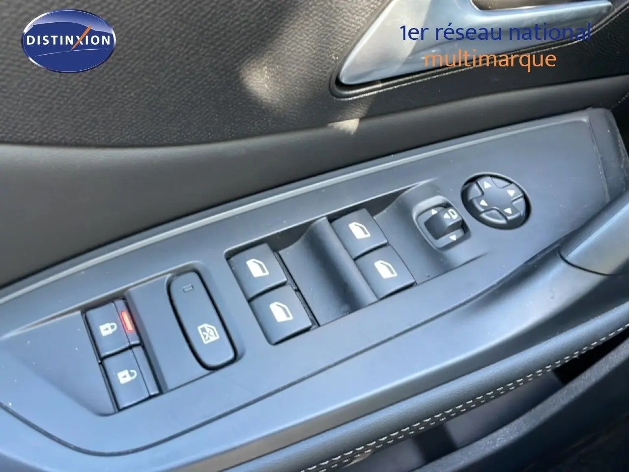 Gros plan sur les commandes de lève-vitres et rétroviseurs côté conducteur d’un Peugeot 308 SW gris Artense.