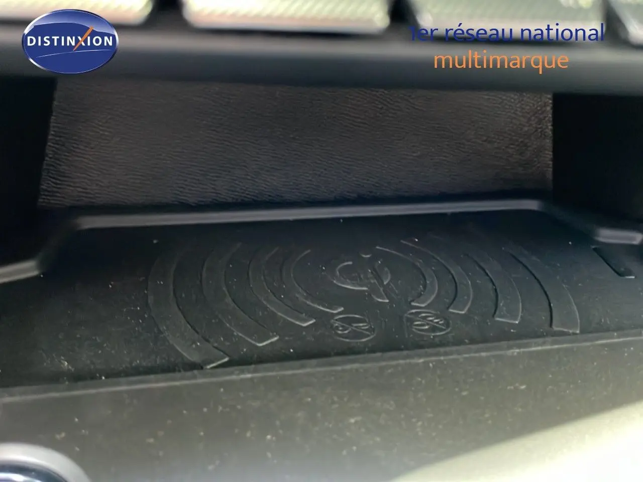 Gros plan sur le chargeur à induction noir dans l’habitacle du Peugeot 308 SW gris Artense Metal 2025.
