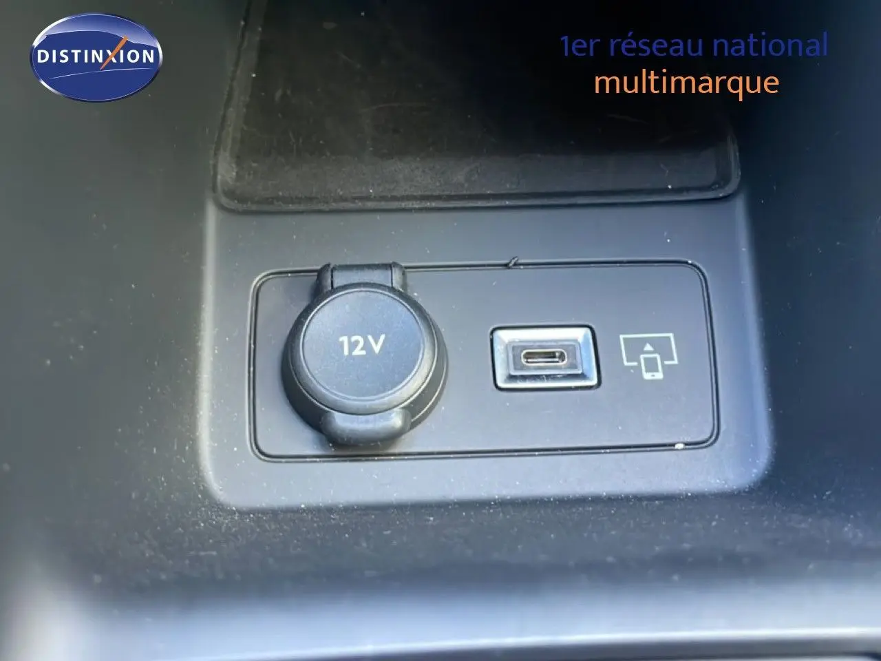 Prise 12V et port USB-C en gros plan sur la console centrale d'une Peugeot 308 SW gris Artense 2025.