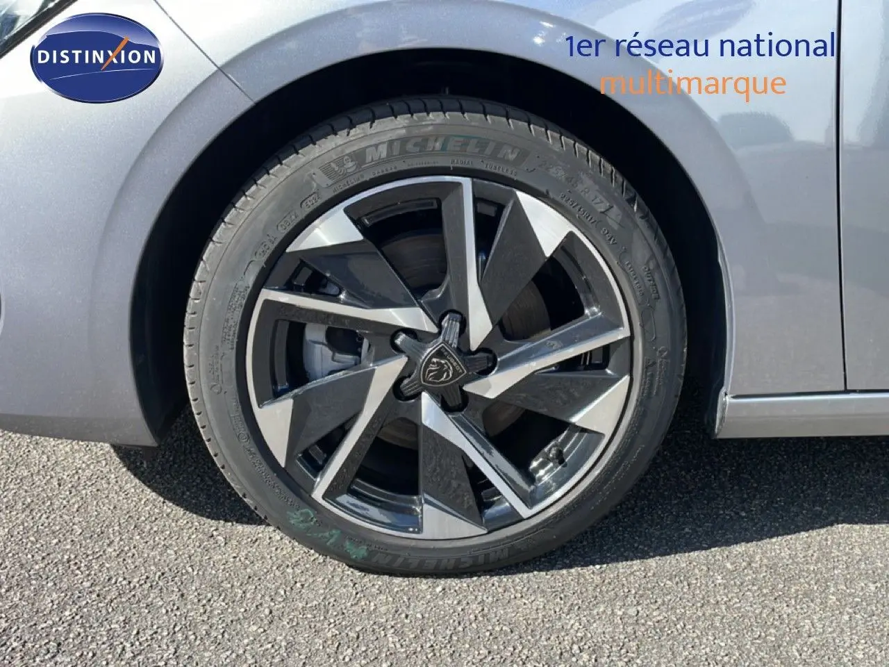 Gros plan sur la roue avant gauche d’une Peugeot 308 SW Hybrid 145ch gris Artense métal avec jante alliage bicolore.