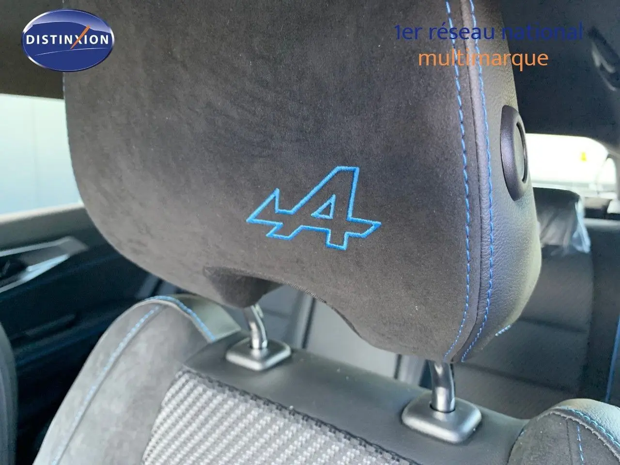 Gros plan sur l'appui-tête noir avec logo bleu "A" et surpiqûres bleues dans l'habitacle du Renault Austral 2024.