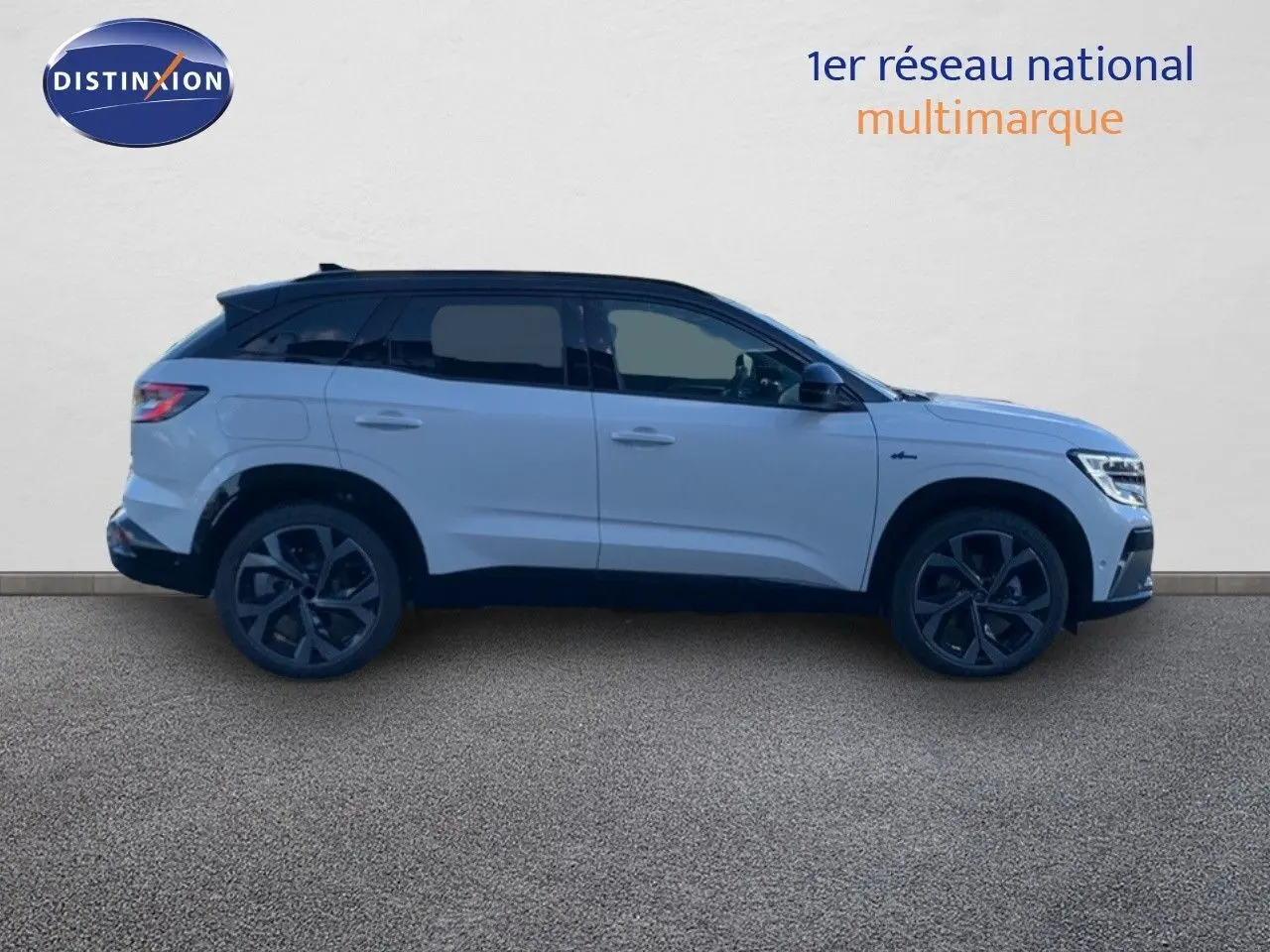 Profil côté droit du Renault Austral 2024 blanc métal avec toit noir, soulignant ses jantes noires et lignes modernes.