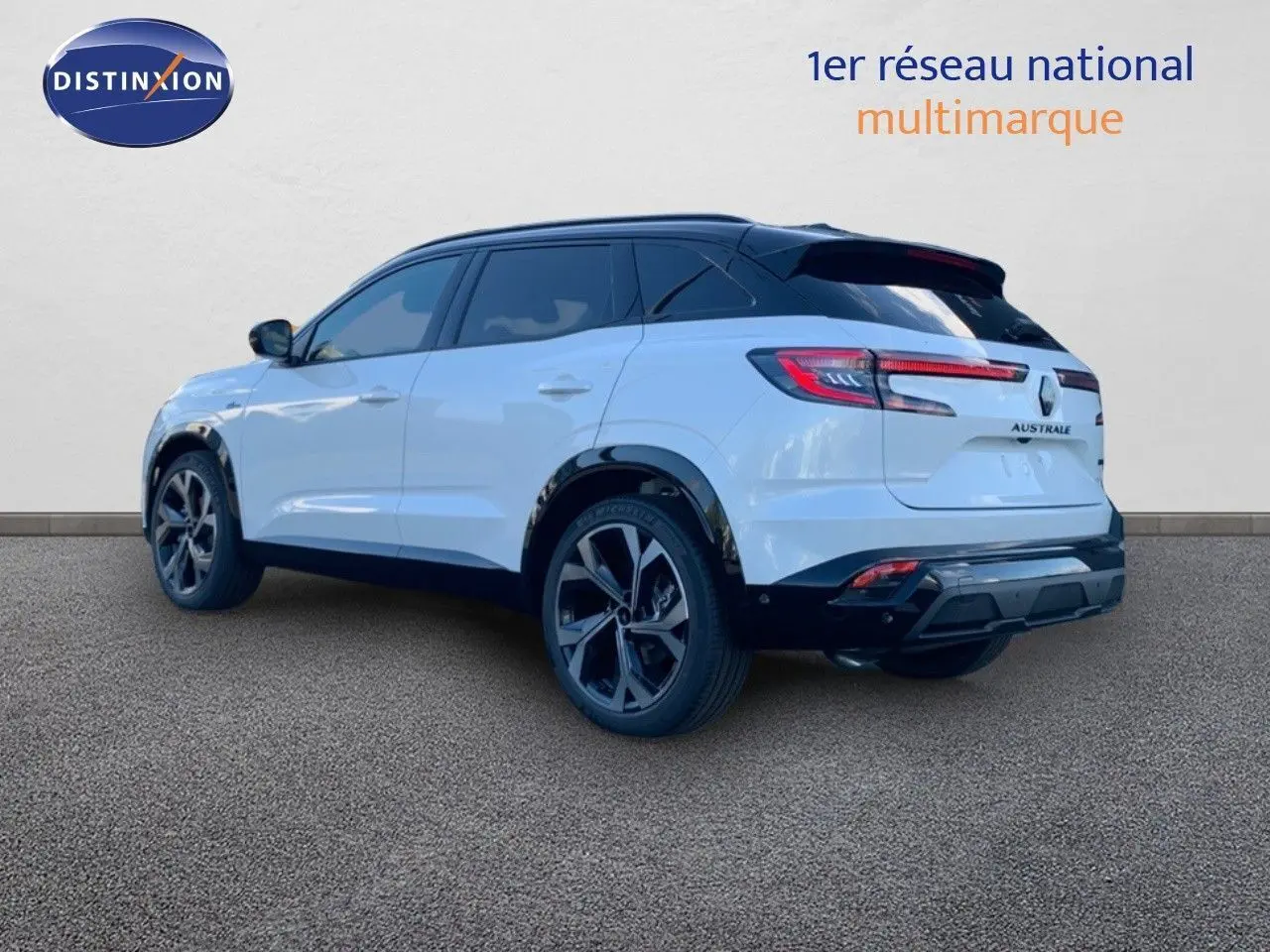 Vue 3/4 arrière droite d'un Renault Austral blanc métal avec toit noir et jantes alliage noires.