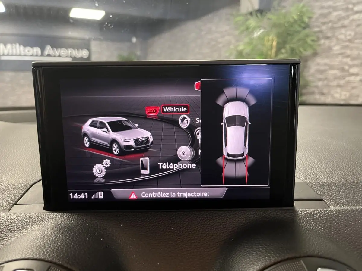 Écran central montrant l'affichage du système d'aide au stationnement de l'Audi Q2 gris de 2019.