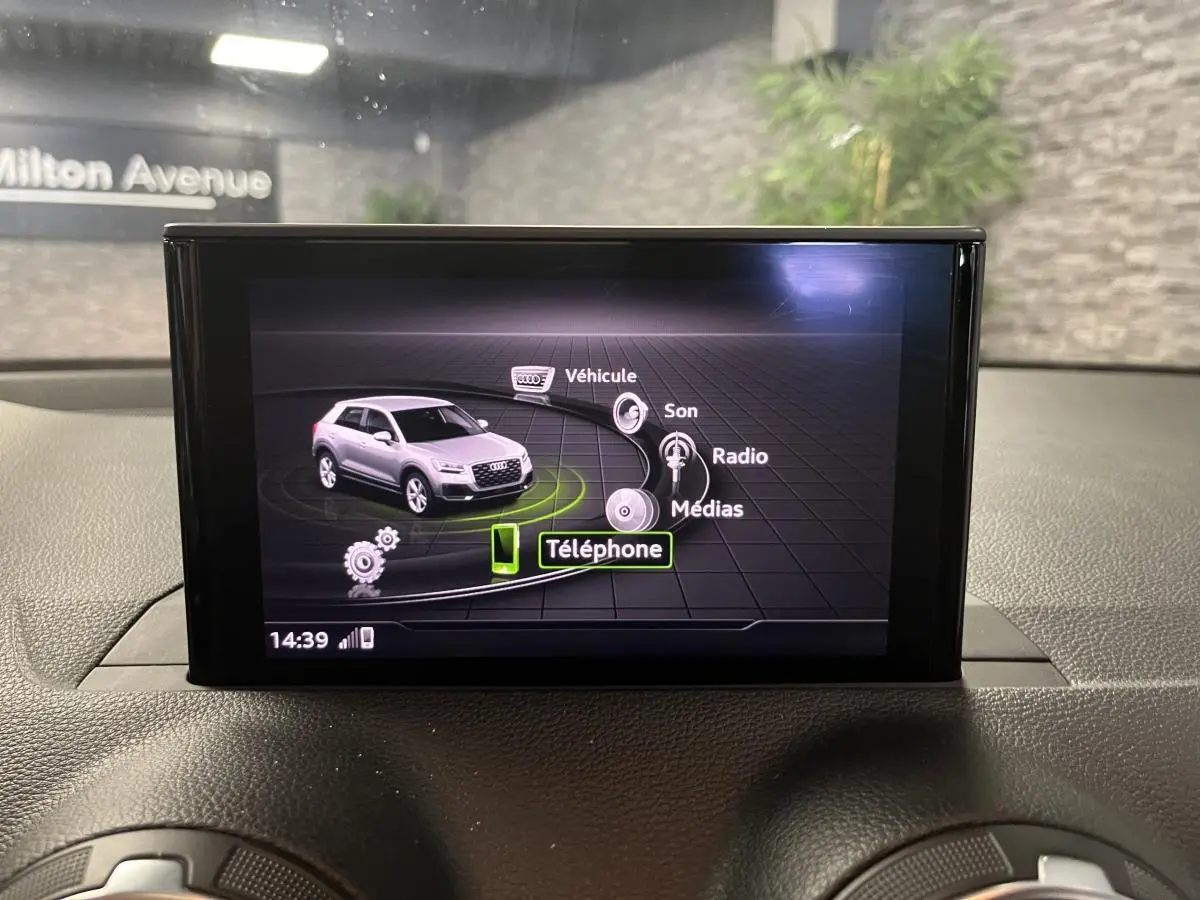 Écran central de l'Audi Q2 2019 affichant le menu multimédia avec icônes pour véhicule, son, radio et téléphone.