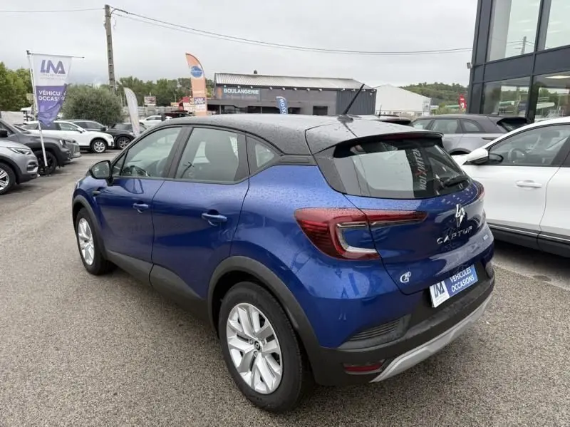 Vue 3/4 arrière droite d'un Renault Captur E-Tech 145 Zen bleu métal 2022 avec toit noir et feux arrière LED distinctifs.