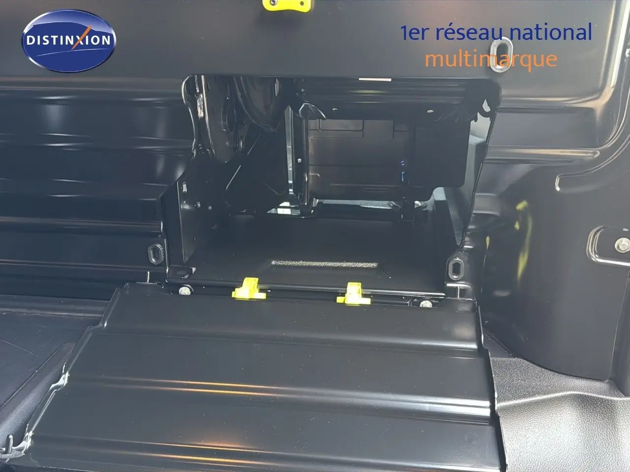 Gros plan sur l'espace de chargement intérieur noir du Citroën Jumpy Fourgon XL gris titane, montrant la cloison et les fixations.