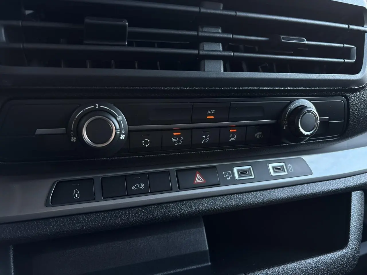 Vue rapprochée de la console centrale noire du Citroën Jumpy XL 2025 avec commandes climatisation et boutons fonctionnels.