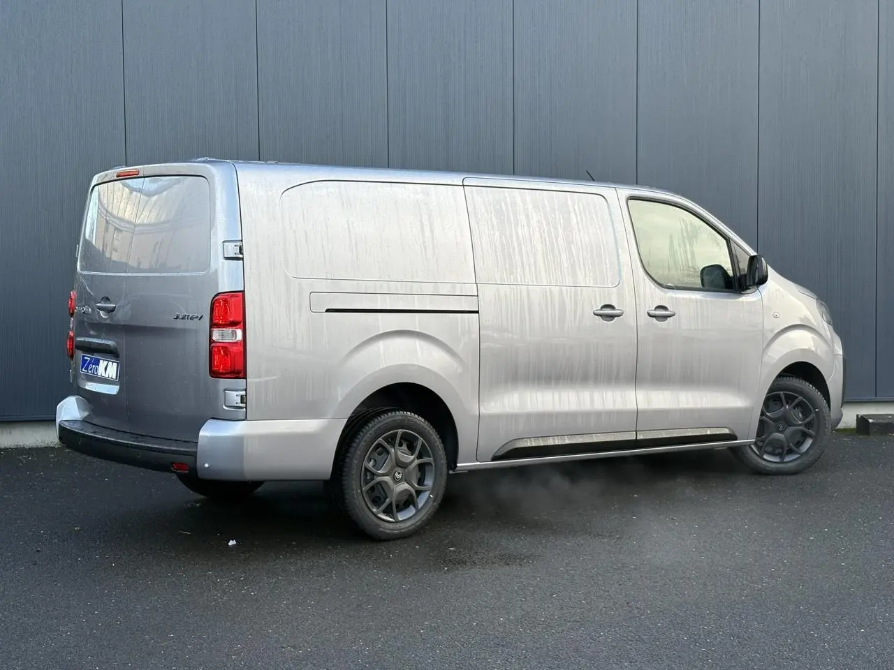 Vue 3/4 arrière droite du Citroën Jumpy XL gris Artense avec bouclier arrière demi-peint et jantes spécifiques.