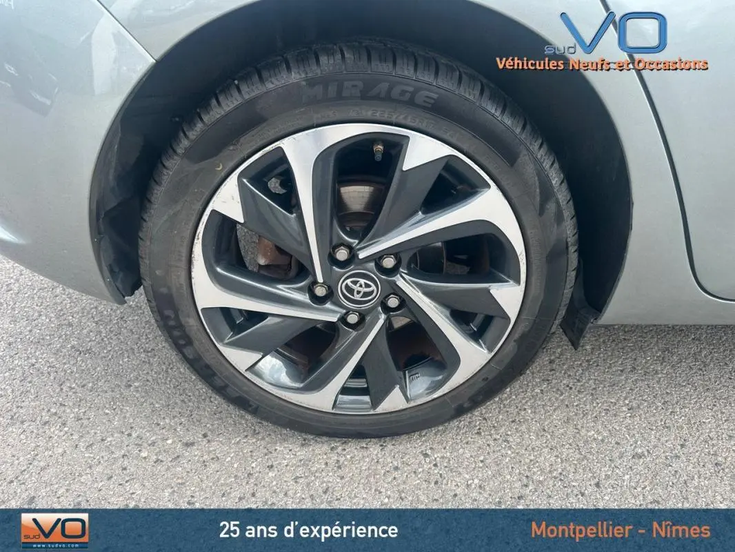 Vue rapprochée de la roue arrière droite d'une Toyota Auris Business Hybride gris clair avec jante alliage 17 pouces.