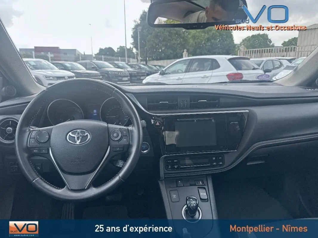 Intérieur de la Toyota Auris Business Hybride 2016, vue du tableau de bord et volant multifonctions noir.
