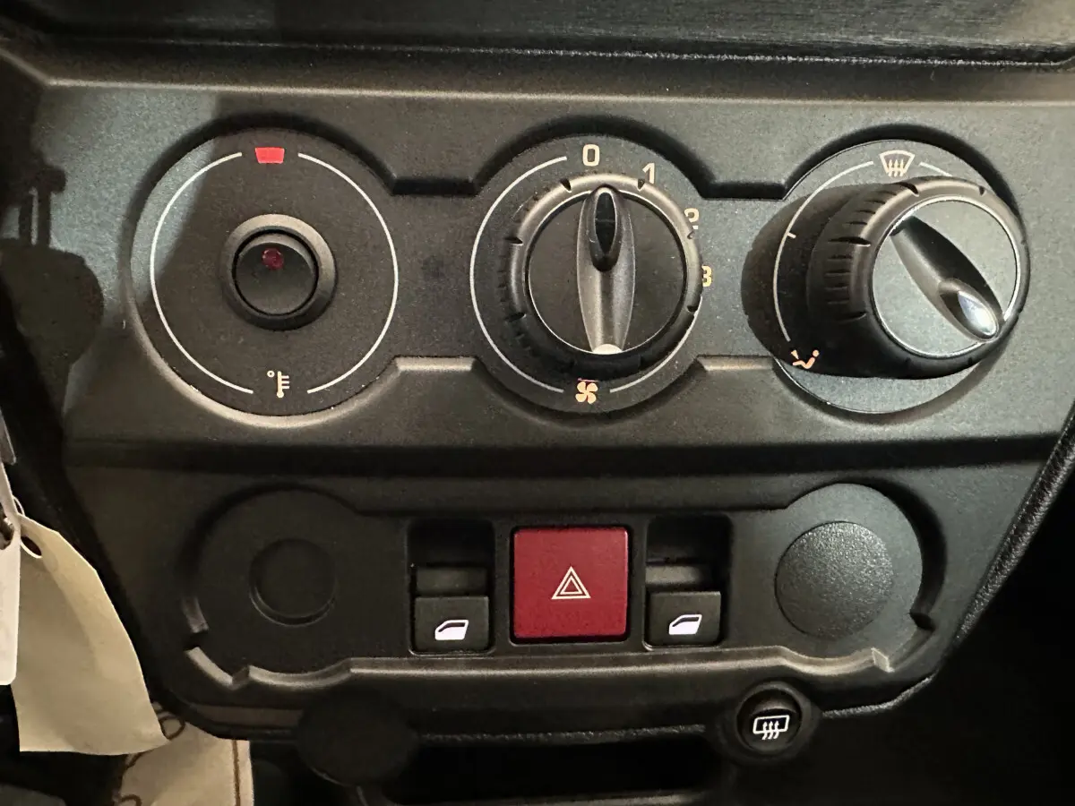 Tableau de bord de l'AIXAM AMBITION E CITY PACK 2025 avec commandes de climatisation et boutons de vitres électriques.