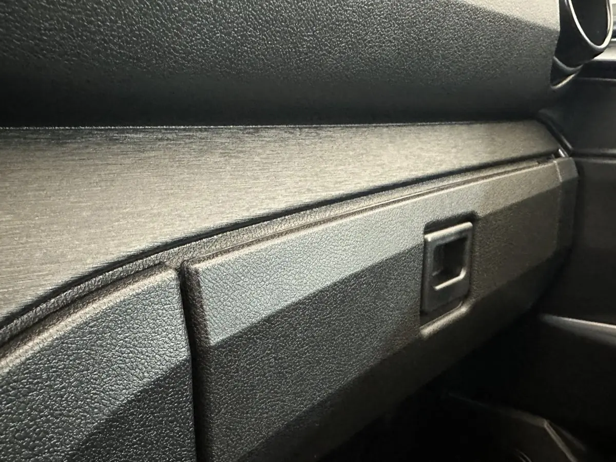 Détail de la boîte à gants noire dans l'habitacle de l'AIXAM AMBITION E CITY PACK 2025.