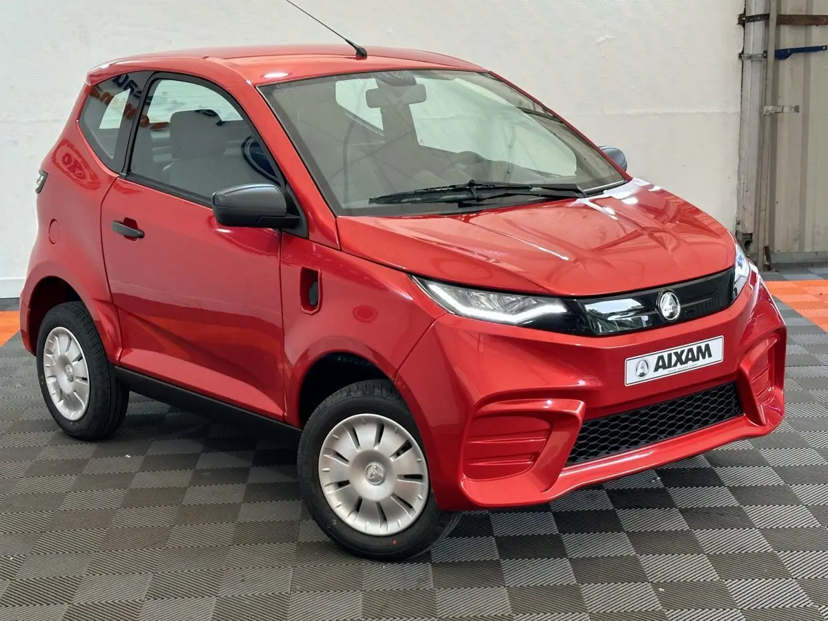 Vue 3/4 avant d'une Aixam Ambition E City Pack rouge 2025 avec rétroviseur caméra côté gauche.
