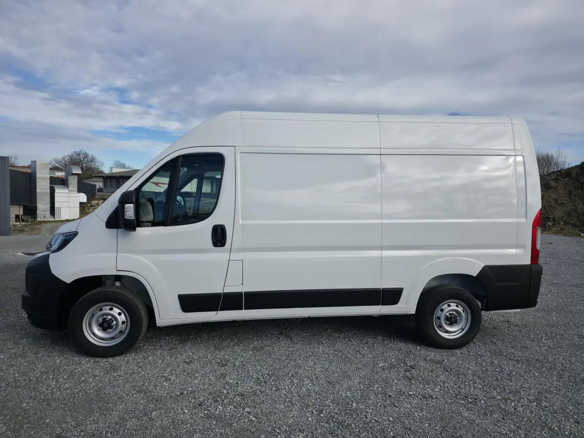 Vue latérale droite du fourgon blanc FIAT Ducato Tôlé 3.3 L H2 2025 avec roues acier et protections noires.