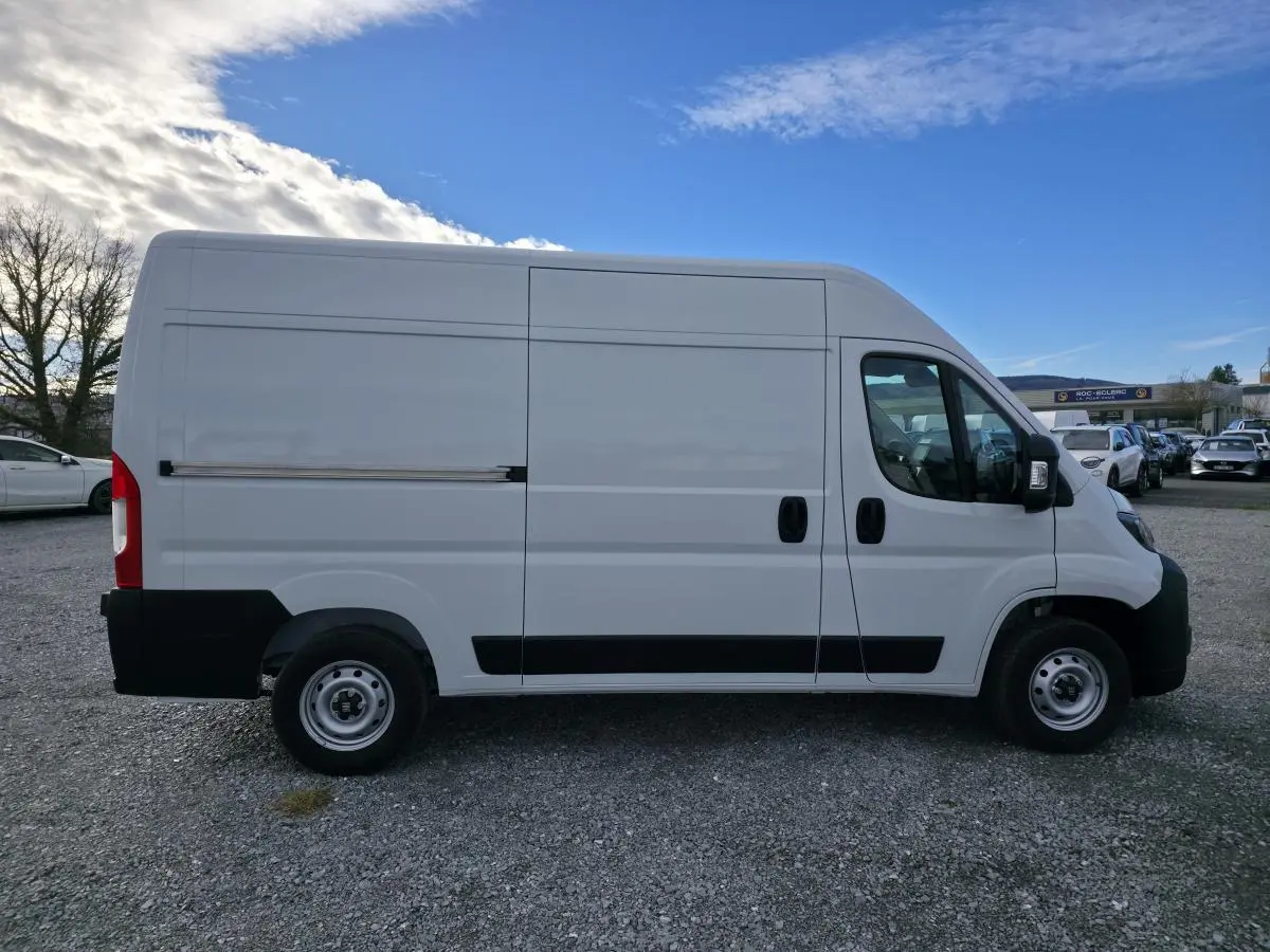 Vue de profil côté gauche d'un FIAT Ducato Fourgon blanc avec porte latérale coulissante et roues acier 15 pouces.