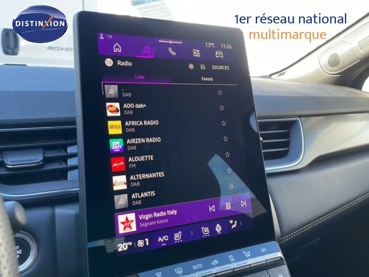 Vue intérieure centrée sur l'écran tactile du tableau de bord du Renault Symbioz bleu, affichant les options radio et climatisation.