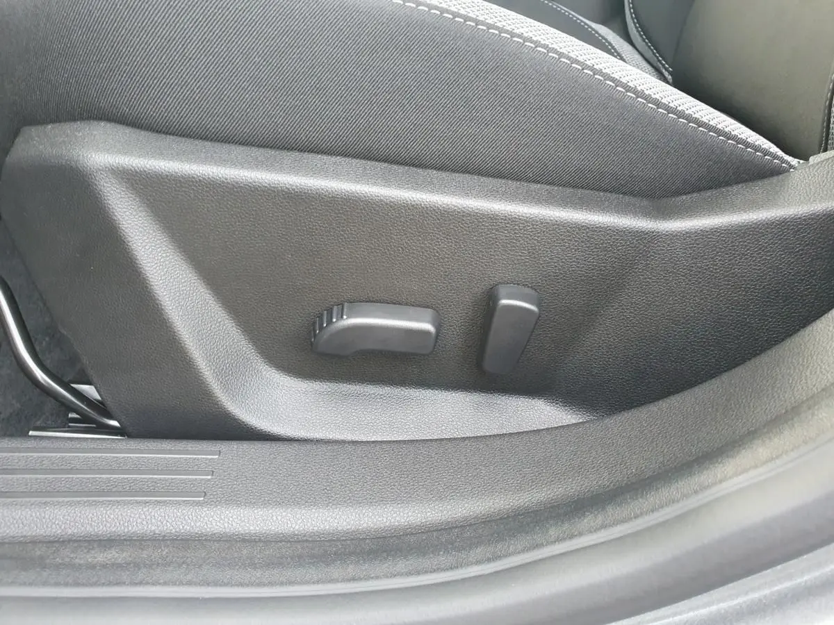 Gros plan sur les commandes de réglage lombaire du siège conducteur du Dacia Bigster, intérieur noir.