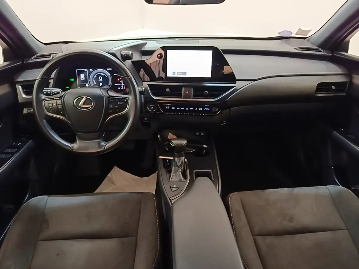 Vue intérieure avant du Lexus UX 250H 2WD Pack Business 2023, tableau de bord noir avec écran tactile central et volant multifonctions.