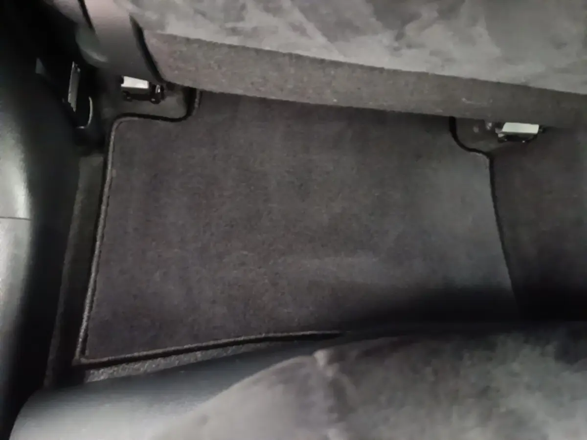 Vue rapprochée du tapis de sol noir côté passager arrière d’un Lexus UX 250H gris clair 2023.