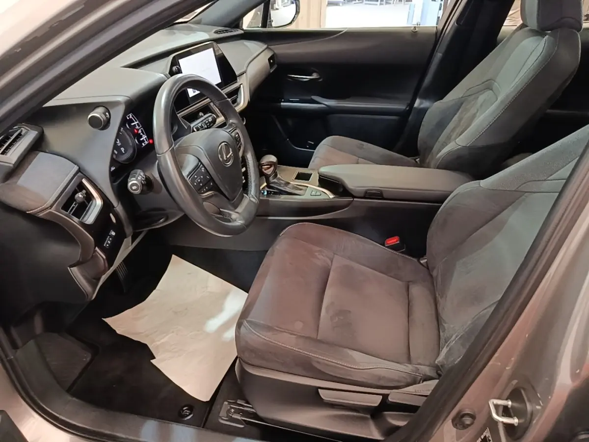 Intérieur avant droit du Lexus UX 250H gris clair, volant cuir multifonctions et écran tactile central visible.