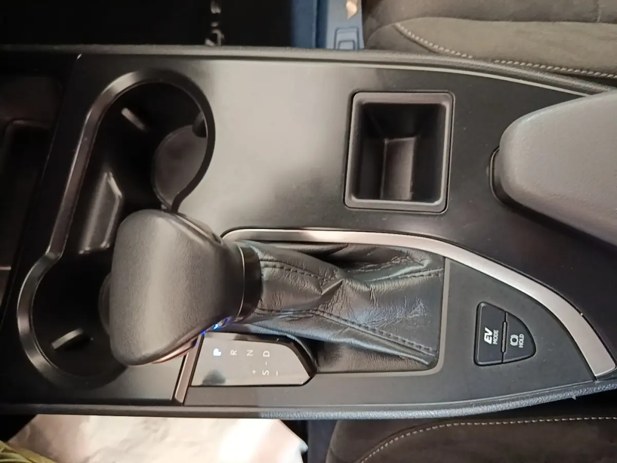 Gros plan sur la console centrale du Lexus UX 250H 2WD gris clair, avec levier de vitesses automatique et boutons EV Mode.