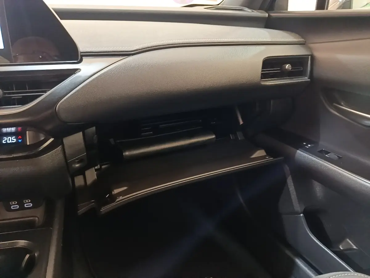 Intérieur du Lexus UX 250H 2WD Pack Business 2023, vue côté passager sur la boîte à gants ouverte et tableau de bord noir.