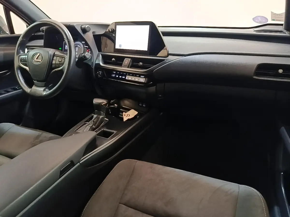 Vue intérieure avant droite du Lexus UX 250H gris clair, avec tableau de bord moderne et écran tactile central.