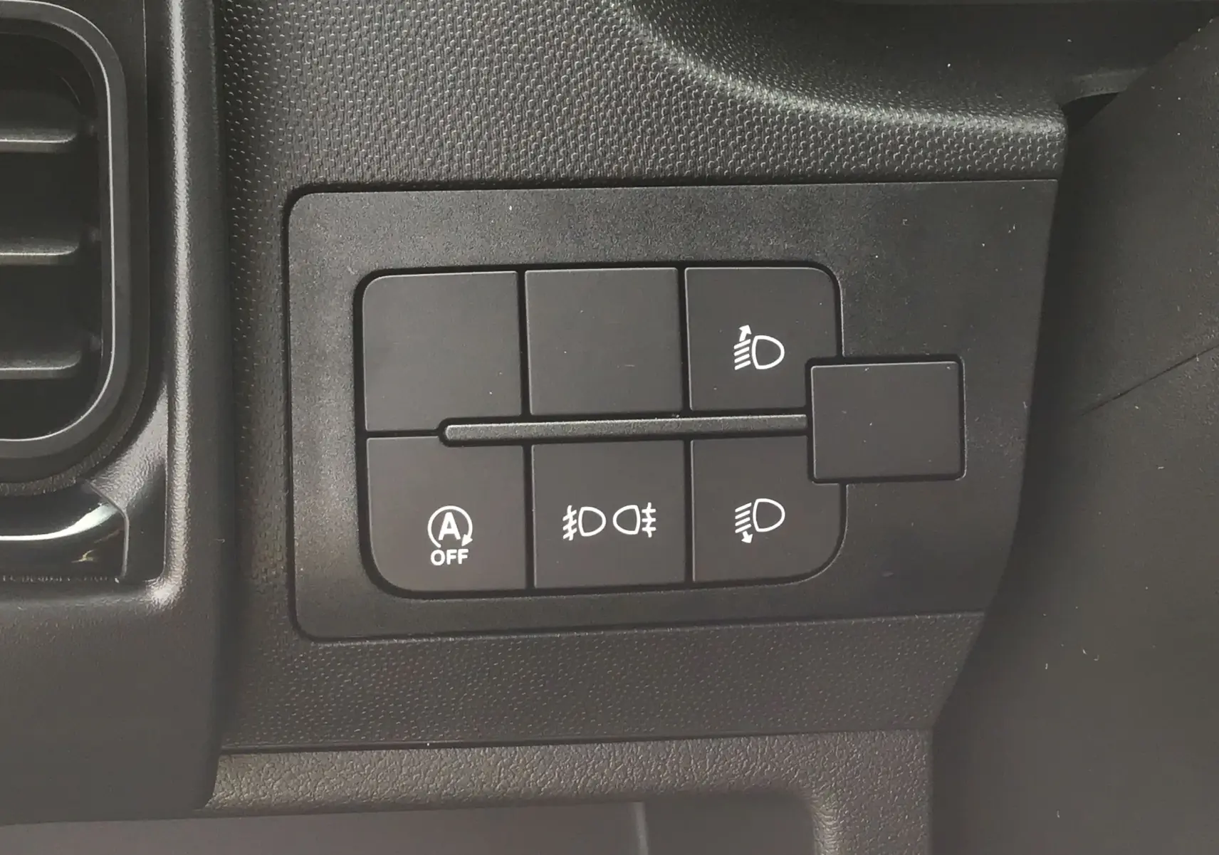 Gros plan sur les commandes d'éclairage noires du tableau de bord du Peugeot Boxer Fourgon blanc 2025.