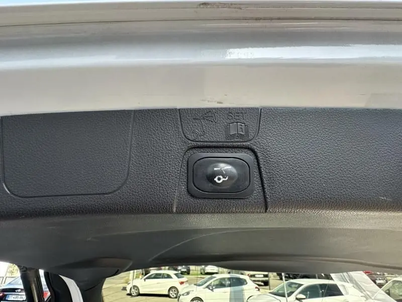 Bouton de fermeture électrique du hayon sur le coffre d'une Ford C-MAX blanche vue de l'intérieur arrière.