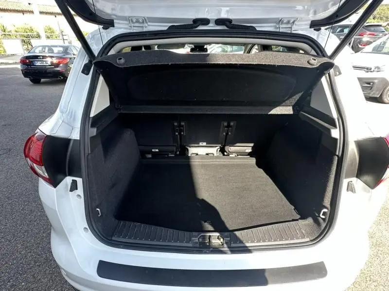 Coffre ouvert vu de l'arrière d'une Ford C-MAX blanche 2017, montrant un espace de chargement propre et spacieux.