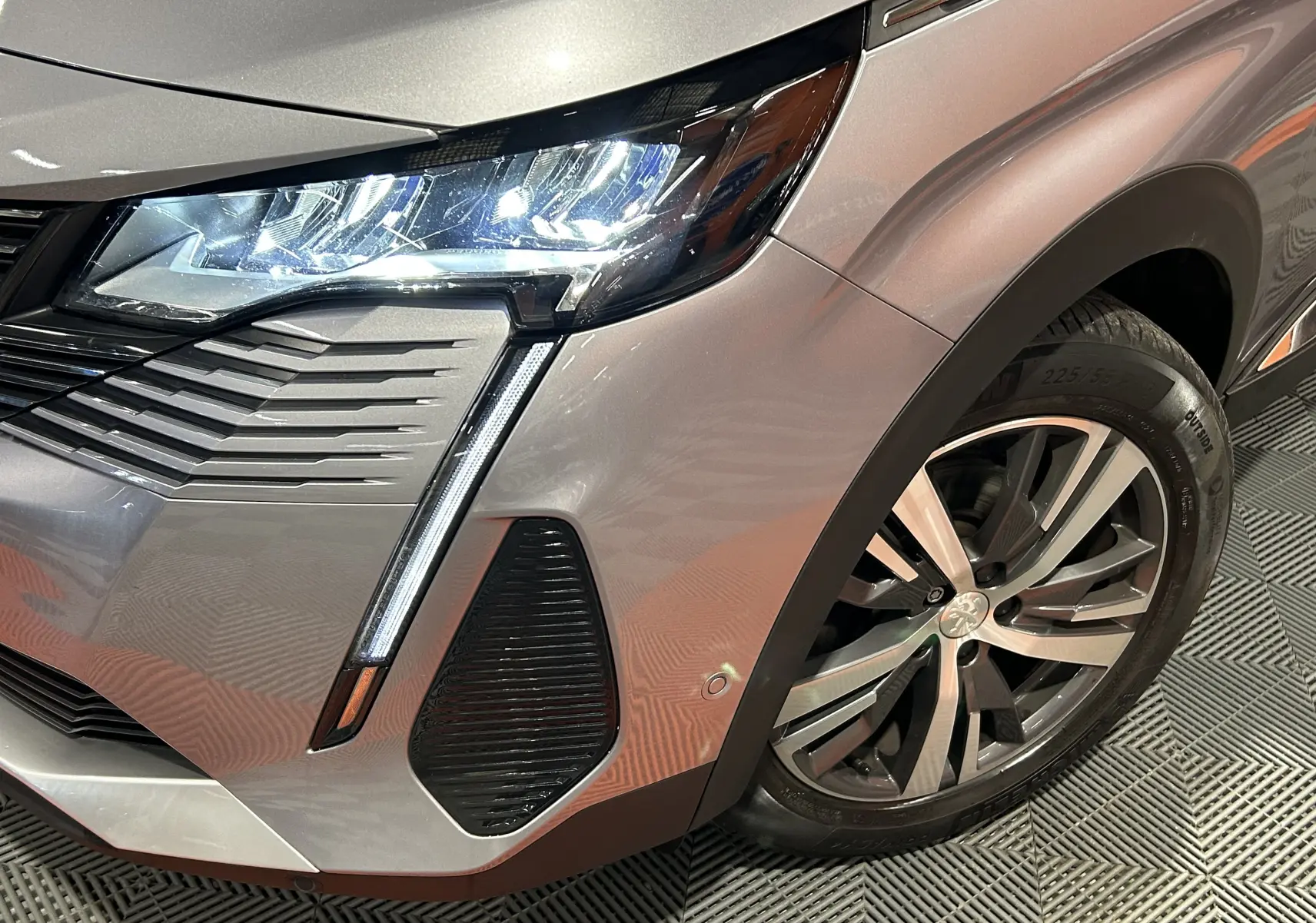 Gros plan sur l'avant droit gris Artense du Peugeot 3008 2022, mettant en valeur le phare LED et la jante alliage.