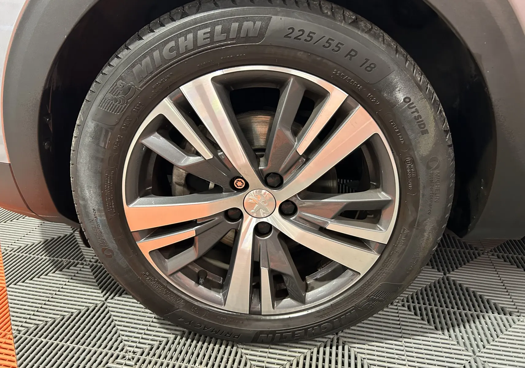 Gros plan sur la jante alliage 18 pouces et pneu Michelin du Peugeot 3008 gris Artense, version Allure avec attelage.
