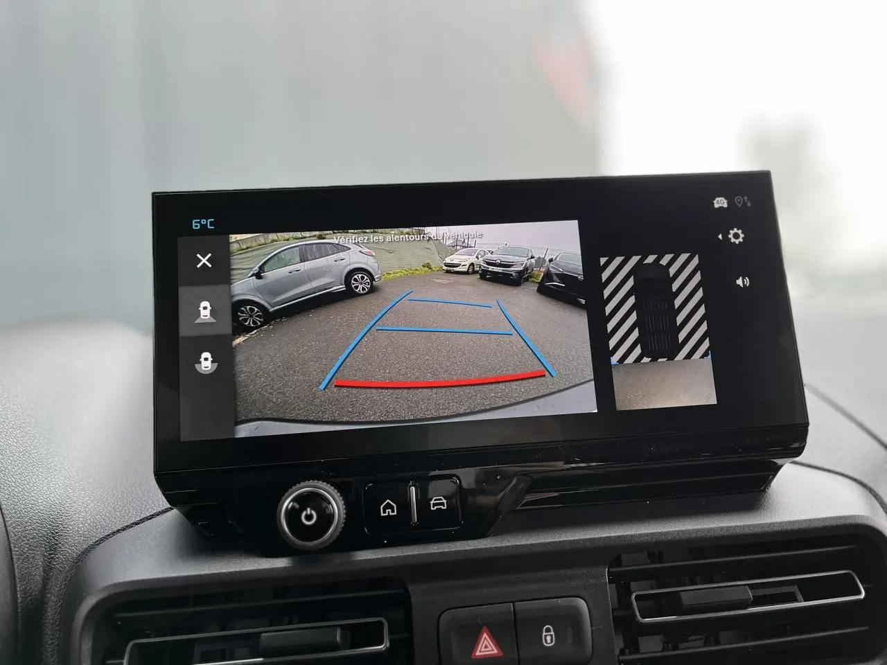 Écran tactile intérieur montrant la caméra de recul avec vue arrière et angles de stationnement du Citroën Berlingo blanc.