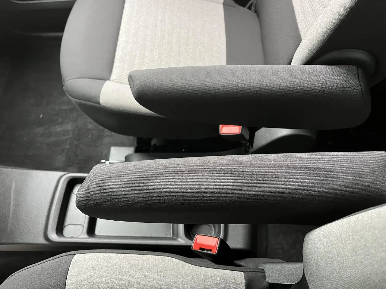 Vue rapprochée des accoudoirs noirs et des sièges gris clair du Citroën Berlingo Multispace 2025.