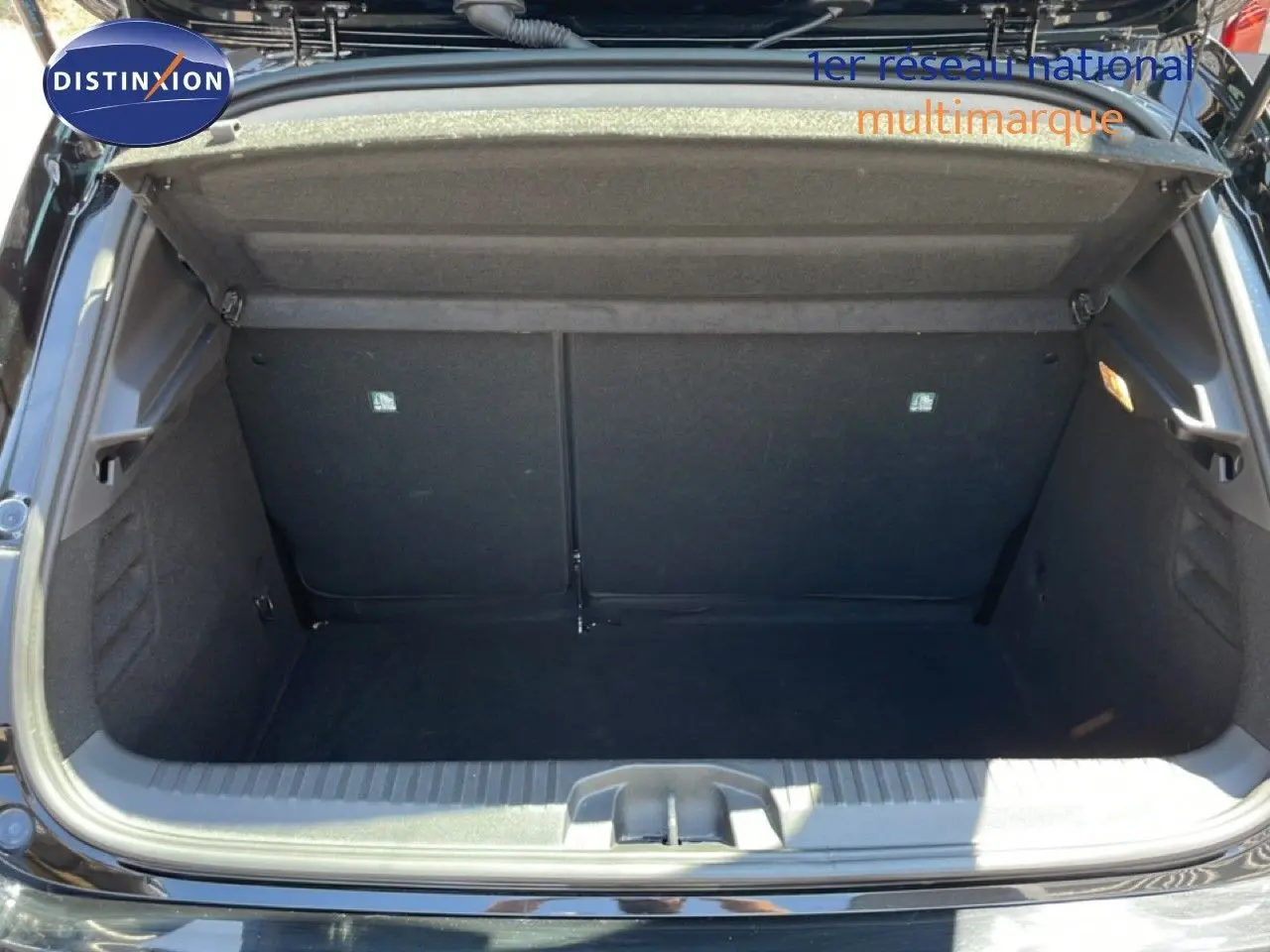 Coffre ouvert de Renault Clio noir étoile métal, vue arrière montrant l’espace de rangement vide et la garniture intérieure.
