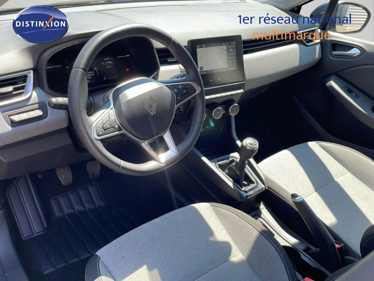 Vue intérieure côté conducteur de la Renault Clio 2025 noir étoile métal, volant cuir, boîte manuelle et écran tactile central.