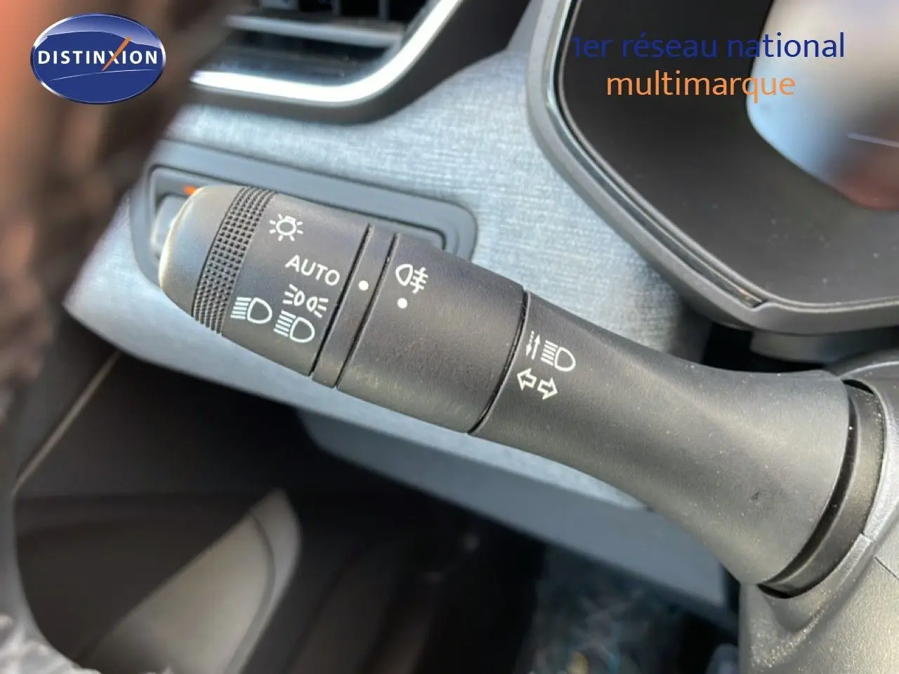 Gros plan sur la commande des phares et clignotants dans l'habitacle d'une Renault Clio noire étoile métal 2025.