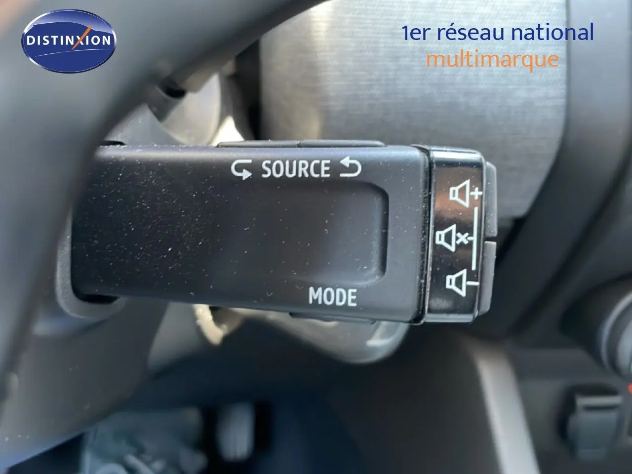 Gros plan sur la commande audio au volant d'une Renault Clio noire étoile métal, version BlueDCI 100ch Evolution 2025.