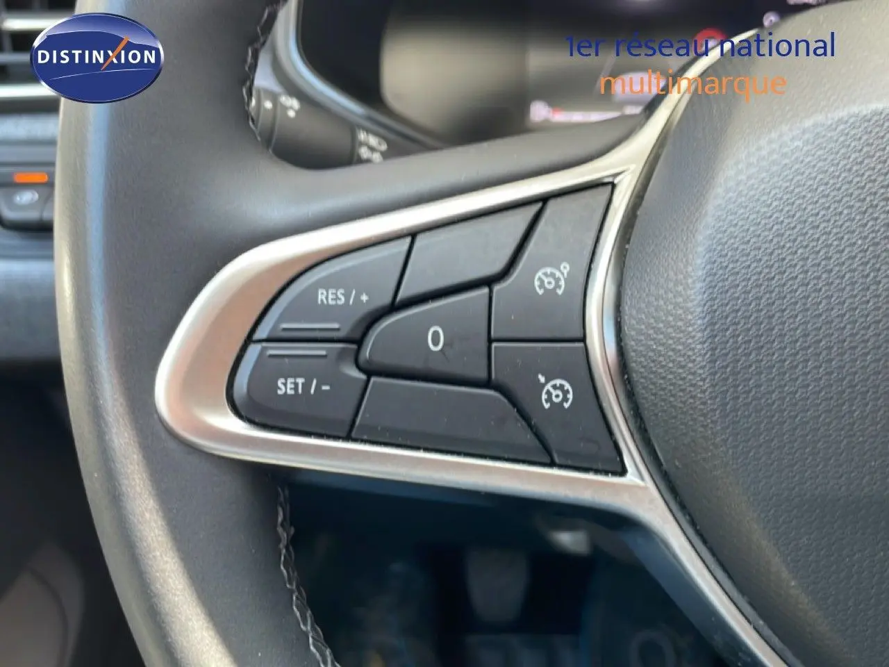 Gros plan sur les commandes de régulateur de vitesse au volant d'une Renault Clio noire étoile métal, version 2025.