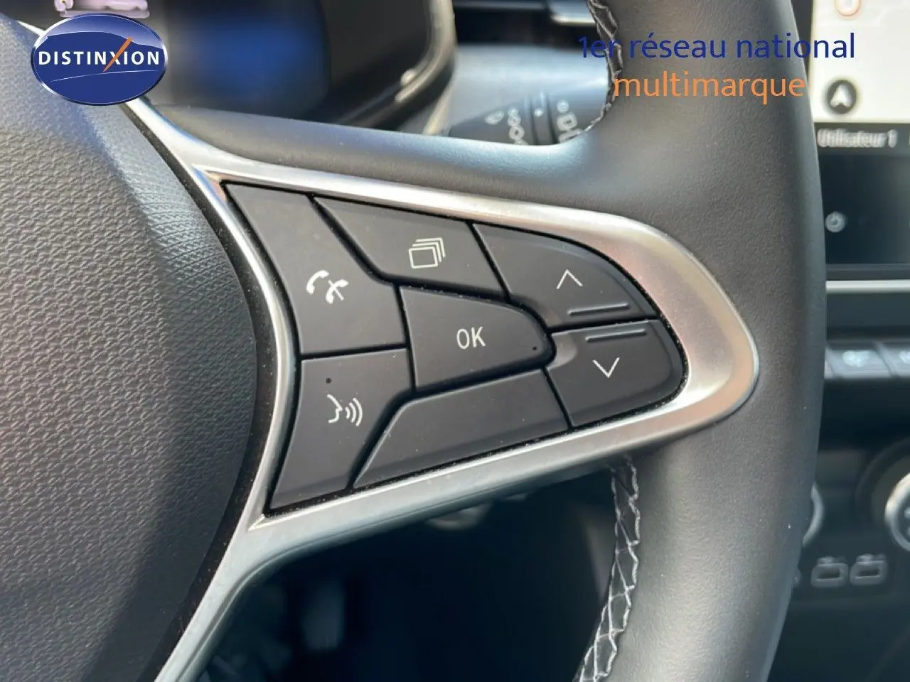 Gros plan sur les commandes multifonctions à droite du volant cuir noir de la Renault Clio V Bluetci 100ch Evolution 2025.