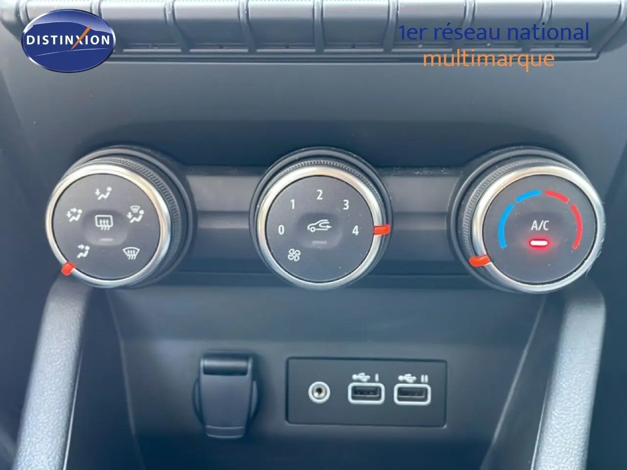 Gros plan sur les commandes de climatisation et les ports USB d'une Renault Clio noire étoile métal, version 2025.