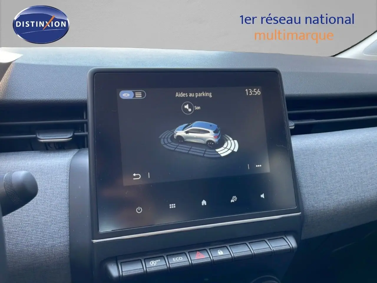 Vue rapprochée de l’écran tactile central affichant l’aide au parking dans l’habitacle d’une Renault Clio noire.