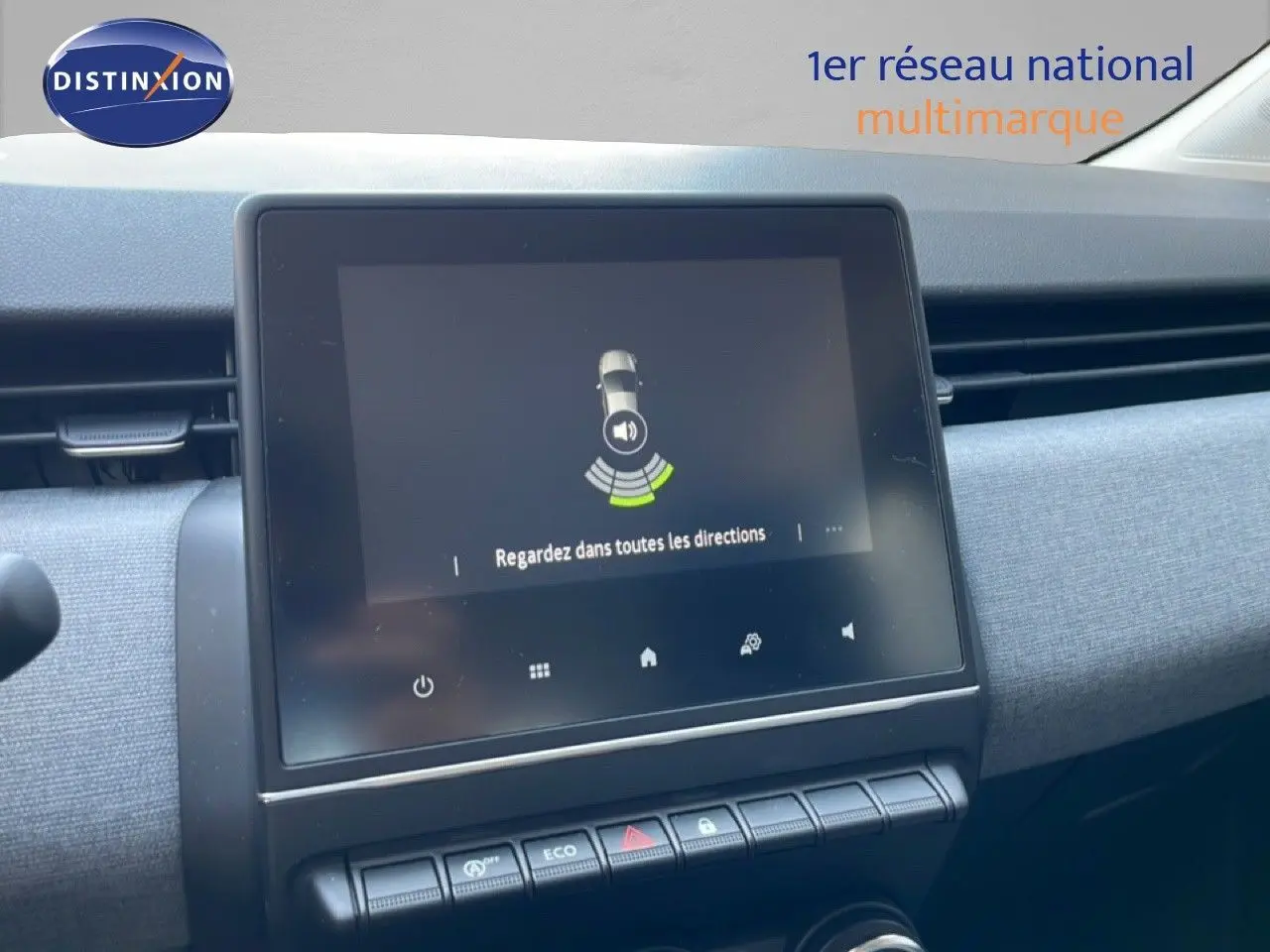 Vue rapprochée de l’écran tactile central de la Renault Clio noire étoile métal, affichant l’aide au stationnement.